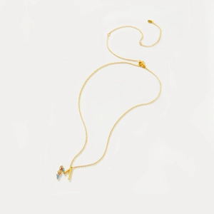 Detailed close-up of S925 silver golden necklace with colorful zircon letter M pendant