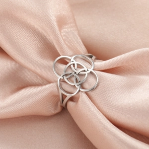 Silver Celtic knot stainless steel ring displayed on soft pink silk background