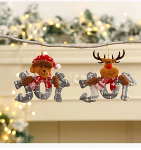 Christmas plush bear and reindeer JOY ornaments hanging on a festive tree branch