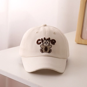 Dettaglio del ricamo della tigre e scritta CUTE sul cappellino in cotone beige