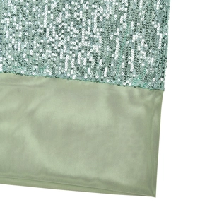 Dettaglio di paillettes verde chiaro e tessuto a rete su un elegante abito da sera