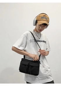 Neutral street style black nylon crossbody bag with dual front pockets and adjustable strap
