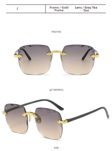 Close-up of rimless square sunglasses with gradient grey tea lenses and gold metal trim