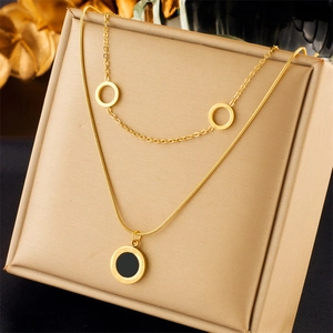 Gold double-layered necklace with Roman numeral black pendant and cutout circles