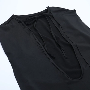 Detail view of backless black dress featuring deep U-neck cut and thin lace-up straps