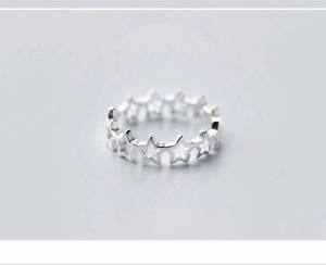 Makro-Detail eines silbernen Hohlstern-Rings mit poliertem Finish und Sternenmuster