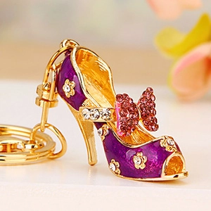 Macro detail of purple high heel keychain with pink bow and crystal encrusted metal
