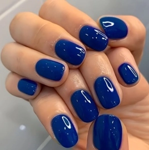 Macro shot of deep blue mirror finish almond shape press-on nails with glossy surface