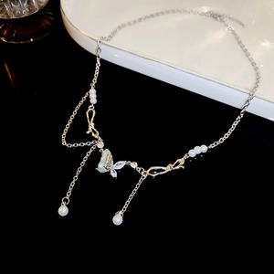Detail of silver butterfly pendant necklace with pearls and zircon tassels on tray