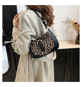 Detail view of leopard print shoulder bag with black leather trim and knot strap detail