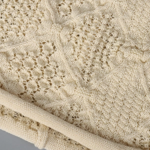 Macro view showing the intricate cream hollow-out knit texture of this elegant crochet hat
