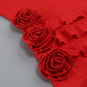 Detail of red dress featuring three 3D fabric roses and elegant ruffled hemline