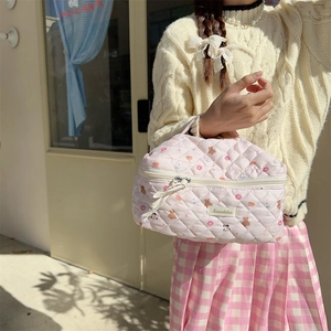 Close-up of pink quilted cotton makeup bag featuring cute bear and donut patterns