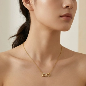 Close-up of 18k gold-plated infinity necklace with small diamonds on model's neck