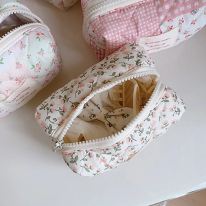 Detail of quilted cotton makeup bag with floral patterns and zipper closure in a macro view