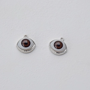 Macro shot of silver-plated evil eye charms with brown iris detail for DIY jewelry making