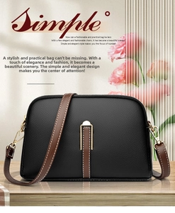 Close-up of black litchi grain leather shell bag with brown strap and golden hardware