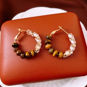 Detailed view of vintage gold hoop earrings with brown tiger eye beads and cubic zirconia