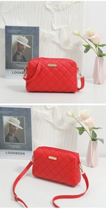 Macro shot of red quilted crossbody bag with gold hardware and long shoulder strap