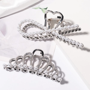 Elegant silver metal hair claws with white pearls in bow and crown shapes on satin