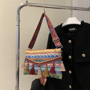 Detail of bohemian woven shoulder bag with vibrant geometric patterns and colorful tassels