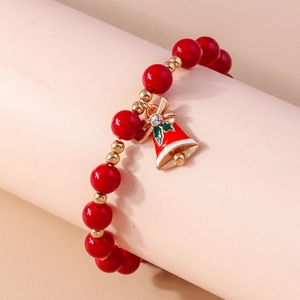 Detail of red Christmas beaded bracelet featuring a festive gold bell with a tiny rhinestone