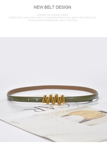 Detail of green leather belt with wave-shaped gold buckle on open magazine page