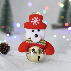 Close-up of plush Christmas bear ornament with golden star cutout bell and holiday ribbon