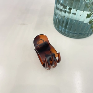 Pince à cheveux motif écaille de tortue pour queue de cheval haute sur surface blanche