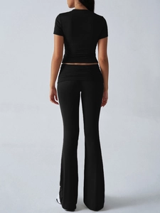Rear view of black yoga set featuring a cropped short sleeve tee and flared yoga pants