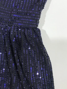 Primer plano de lentejuelas moradas y tejido de malla plisada en el vestido en V