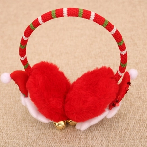 Detail of red plush Christmas earmuffs with striped knit headband and golden bells