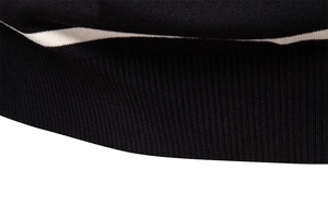 Close-up of black ribbed knit fabric with cream stripes on a men's polo sweater