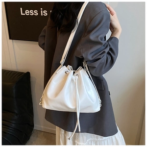 Nahaufnahme einer weißen Leder-Beuteltasche mit silbernen Ösen getragen von einem Model