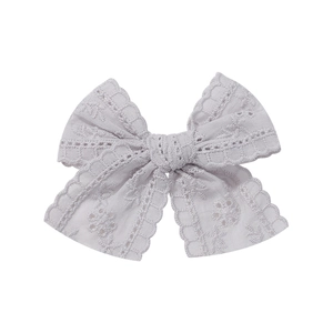 Close-up of lavender lace bow hair clip with intricate hollow embroidery details