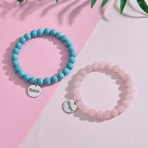 Detail of personalized natural stone bracelets with engraved stainless steel charms