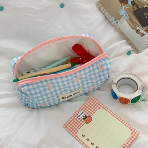 Detailed view of blue checkered makeup bag with pink zipper and large storage space