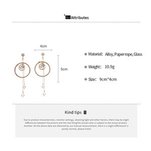 Detail of bohemian drop earrings with paper rope circles, star-moon charms and glass beads