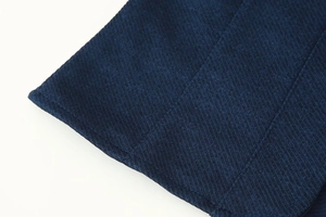 Vue détaillée du tissu en sergé bleu marine et des coutures de qualité sur l'ensemble