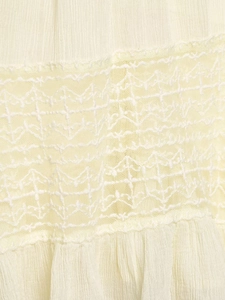 Detailed macro view of beige lace trim and pleated chiffon fabric texture on this blouse