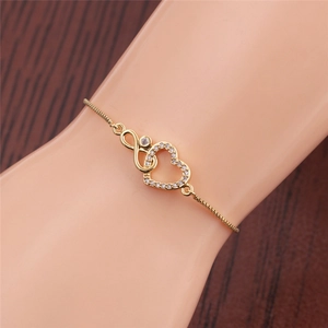 Detail of adjustable gold infinity heart bracelet with white zircon on wrist