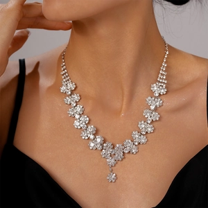 Detail of silver multi-layered sunflower necklace with crystals on model's neckline