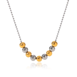 Close-up of dual-tone gold and silver metal beads on a fine steel necklace chain