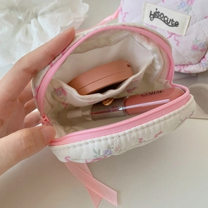 Mini floral makeup bag with pink bow ribbon showing internal storage capacity