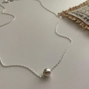 Minimalist 925 sterling silver chain necklace with 8mm round bead on grey background