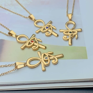 Detail of four golden Eye of Horus Ankh necklaces with colorful zircon stones on book pages