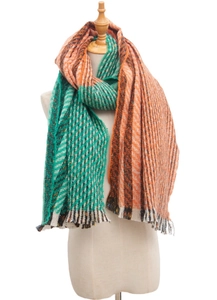 Close-up of orange and green striped knit scarf texture with delicate fringe detail