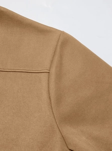 Detailed macro shot of the shoulder stitching on a brown slim fit hooded trench coat