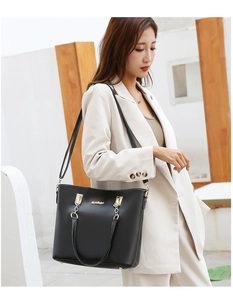 Chic black faux leather shoulder bag with gold chain strap shown on a female model