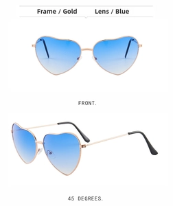 Detail view of heart-shaped sunglasses with gold metal frames and blue gradient lenses